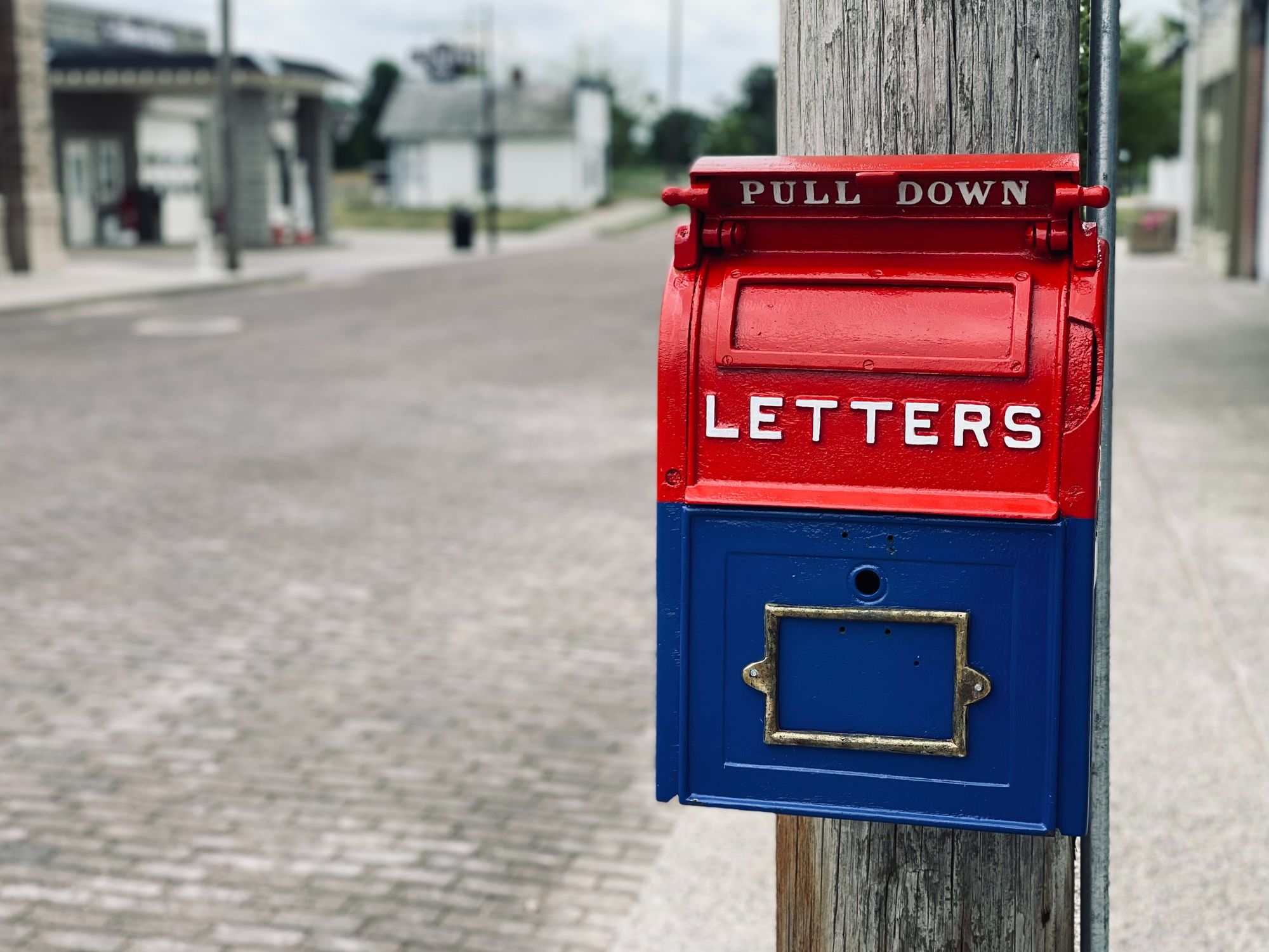 Red and blue mailbox that says "Pull down" and "Letters" on it